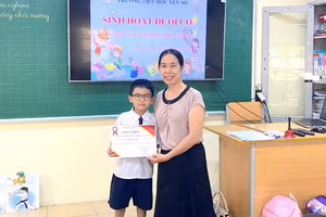 Cô giáo Nguyễn Thị Hồng - Hiệu trưởng trường Tiểu học Yên Sở tặng giấy khen cho em Phạm Tùng Lâm vì hành động đẹp.