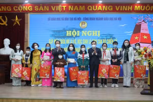 Giám đốc Sở GD&ĐT Hà Nội Trần Thế Cương và Phó Chủ tịch Liên đoàn Lao động TP Hà Nội Nguyễn Chính Hữu tặng quà cho các giáo viên, học sinh 