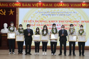 Thứ trưởng Bộ GD&ĐT Nguyễn Hữu Độ và Phó Bí thư Thành ủy Hà Nội Nguyễn Văn Phong trao Bằng khen của UBND thành phố cho các học sinh.