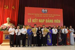 Đồng chí Trương Thị Mai tặng hoa chúc mừng hai đảng viên mới và Đảng bộ nhà trường