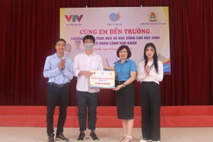 Bà Đặng Hoàng Anh- Phó Chủ tịch Công đoàn Giáo dục Việt Nam trao học bổng cho em Nguyễn Duy Phong.