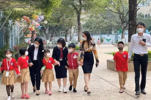 Các em học sinh lớp 1 trường Tiểu học Đặng Trần Côn (quận Thanh Xuân) được các cô giáo hướng dẫn tham quan trường lớp