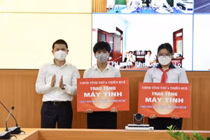 Ông Hoàng Hải Minh - Phó Chủ tịch UBND tỉnh Thừa Thiên Huế trao tượng trưng máy tính tặng cho 2 em học sinh mồ côi cha mẹ do Covid-19. (Ảnh tư liệu)