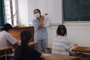 Cán bộ coi thi tại điểm thi Trường THPT Phan Châu Trinh (Đà Nẵng) hướng dẫn thí sinh ghi các thông tin cá nhân vào giấy làm bài thi. 