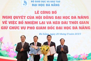 Giám đốc ĐH Đà Nẵng (bên phải) và Chủ tịch Hội đồng ĐH Đà Nẵng trao các Nghị quyết và tặng hoa chúc mừng các Phó Giám đốc. 