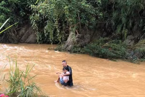 Hình ảnh bé gái được cứu khỏi dòng nước lũ tại huyện Văn Yên.