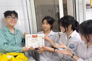 Nguyễn Quốc Huy đón Giấy khen Học sinh giỏi từ các bạn trên giường bệnh.