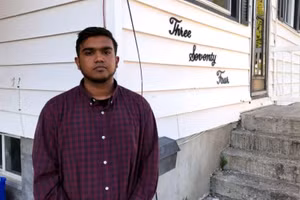 Victor chụp ảnh bên ngoài căn nhà trọ tồi tàn tại Canada.