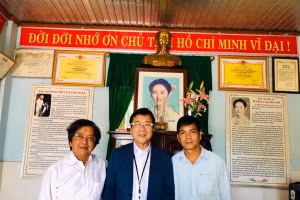 Ông Takahashi (giữa) cùng GS.TS Trần Văn Nam (bìa trái) và thầy Hiệu trưởng Lê Quốc Hà trước di ảnh của Takahashi Junko ở phòng truyền thống của Trường Tiểu học Junko trong chuyến thăm trường vào năm 2019. 