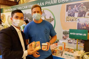 Nguyễn Hữu Hạnh (ảnh trái) giới thiệu sản phẩm cho du khách quốc tế.