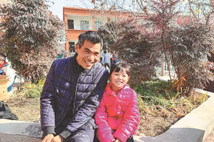 Thầy giáo Zhang Pengcheng (trái) chụp ảnh cùng học sinh Trường Tiểu học Erlangmiao.