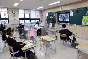 Một GV vừa dạy trực tuyến vừa dạy trực tiếp ở một trường học tại Seoul.