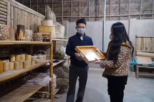 Thái Đăng Tiến - Giám đốc công ty Trà Lân BAMBOO (huyện Con Cuông, Nghệ An) giới thiệu các sản phẩm mỹ nghệ làm từ tre cho du khách.