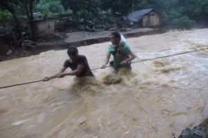 Người dân nỗ lực vượt lũ để đến những vùng bị cô lập. (Ảnh: A Cớ)
