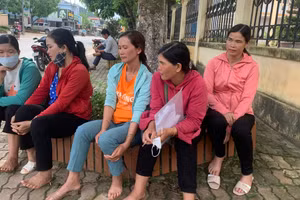 Chị Điêu Thị Luyến (áo cam ngồi giữa) cùng những bà mẹ thấp thỏm đợi con ngoài phòng thi.