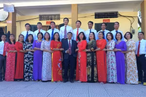 Thầy Nguyễn Hữu Dũng (áo đen đứng giữa) chụp ảnh lưu niệm cùng tập thể giáo viên toàn trường.