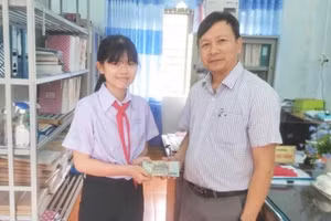 Gia Linh giao lại số tiền nhặt được cho Ban giám hiệu nhà trường.