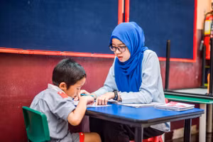 Một trẻ mẫu giáo tại Malaysia đang tập đọc, viết.