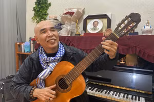 Nhạc sĩ Ngọc Thịnh say sưa bên cây đàn. Ảnh: Ngô Khiêm.