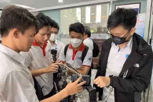 Trần Lê Phước (trái) giới thiệu hệ thống chống ngập tích hợp vào xe máy với các sinh viên cùng trường.