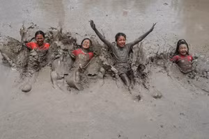 Trẻ em bị bùn cuốn hút như nam châm trước sắt. Ảnh: Getty Images.
