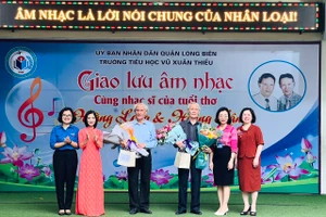 Đại biểu Ban Giám hiệu Trường Tiểu học Vũ Xuân Thiều và lãnh đạo các phòng ban UBND quận Long Biên chúc mừng nhạc sĩ Hoàng Long và Hoàng Lân. Ảnh: NTCC