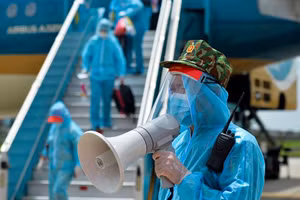 Nhân viên an ninh sân bay Nội Bài hướng dẫn hành khách về các khu cách ly tập trung theo quy định.