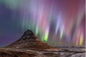 Cực quang thắp sáng bầu trời đêm Kirkjufell, một ngọn núi ở Iceland. Ảnh: Babak Tafreshi