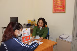 Sinh viên Nguyễn Kim Huệ được cán bộ Công an phường Đông Ngạc hướng dẫn các thủ tục hành chính.