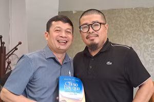 Nhà báo Nguyễn Tri Thức (trái) tặng sách tác giả. Ảnh: NVCC.