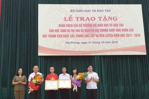 Ông Doãn Hồng Hà, Phó Vụ trưởng Vụ Giáo dục chính trị và Công tác học sinh, sinh viên trao Bằng khen cho học sinh và bà Đỗ Thị Hòa, Phó Giám đốc sở GD&ĐT Hải Phòng tặng hoa cho phụ huynh. 