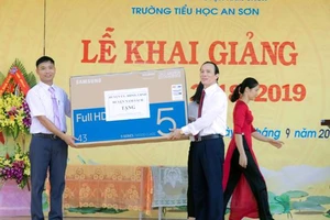 Đồng chí Lê Quang Thụ - phó bí thư thường trực huyện ủy (bên phải ) đại diện Huyện ủy, HĐND, UBND huyện tặng quà cho nhà trường.