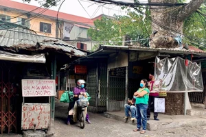 Trên trục đường chính, mặc dù đóng cửa hàng nhưng các tiểu thương vẫn đứng ngoài mời khách mua hàng.