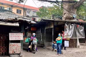 Trên trục đường chính, mặc dù đóng cửa hàng nhưng các tiểu thương vẫn đứng ngoài mời khách mua hàng.