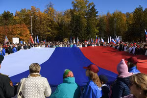 Mọi người cầm lá cờ Nga khổng lồ ủng hộ cuộc trưng cầu dân ý về việc gia nhập Nga của Cộng hòa Nhân dân Donetsk và Lugansk (DPR, LPR), cũng như các phần do Nga kiểm soát ở khu vực Zaporozhye và khu vực Kherson của Ukraine 