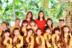 Cô Hiệu trưởng Hứa Thu Huyền (đứng bên phải) cùng các học sinh đội văn nghệ của trường.