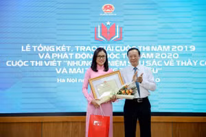 Thứ trưởng Phạm Ngọc Thưởng trao giải Nhất cuộc thi viết “Những kỷ niệm sâu sắc về thầy cô và mái trường mến yêu năm 2019" cho cô giáo Lường Thị Thu Trang. (Ảnh: gdtd.vn)
