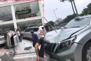 Xe ô tô Vios lao từ tầng 2 showroom xuống đất, đè trúng ô tô Prado rồi lật nghiêng. (Ảnh: Phạm Khánh Vy).