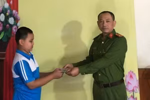 Em Phạm Tiến Thành, học sinh lớp 6A, Trường THCS Hà An bàn giao số tiền 28,5 triệu đồng nhặt được cho Công an phường để trả lại người đánh rơi.
