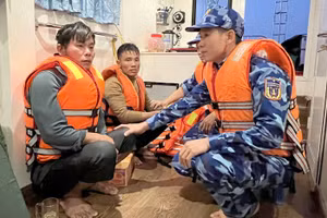 Các chiến sĩ cảnh sát biển động viên 2 thuyền viên bị nạn. Ảnh: CSBVN.