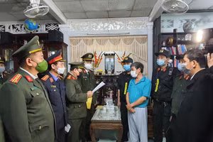 Lực lượng chức năng đọc lệnh bắt tạm giam đối với ông Ngô Thông (áo xanh).