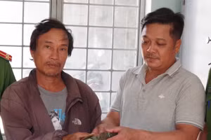 Anh Kiệt (bên trái) trao trả lại số tiền cho gia đình người đánh mất.