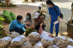 Ông Lưu Tiến Quang (ngoài cùng bên trái) trao đổi với giáo viên về cách phân loại rau, củ, quả trước khi chất lên xe chuyển vào phía Nam.