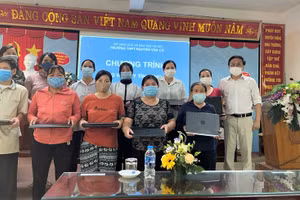 Thầy Nguyễn Minh Phi - Hiệu trưởng Trường THPT Nguyễn Văn Cừ trao laptop cho HS có hoàn cảnh khó khăn.