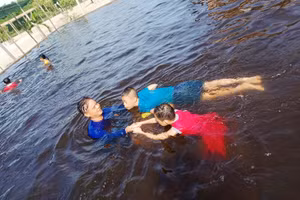 Thầy Tước hướng dẫn cho 2 em khuyết tật các động tác khi bơi.