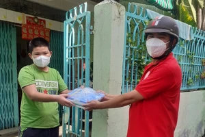 Giáo viên tại Quận 8, TPHCM mang sách đến nhà cho học sinh.