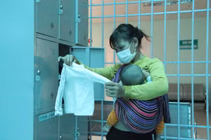 Chị Y Huynh lựa đồ ở “Tủ quần áo từ thiện” cho con trai mới được vài tháng tuổi.