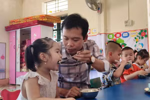 Thầy giáo Trịnh Hồng Quân – Hiệu trưởng Trường Mầm non Thành Sơn (Bá Thước, Thanh Hóa) đang cho trẻ ăn trưa tại trường.