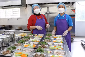 Cô Hà (bìa trái) luôn tất bật với công tác duy trì bếp ăn tại trường. Ảnh: TG