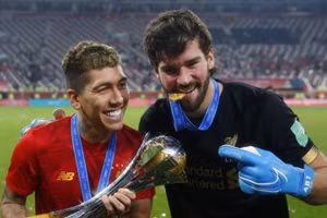 Tiền vệ Roberto Firmino (bên trái) và thủ môn Alisson trong màu áo Liverpool.